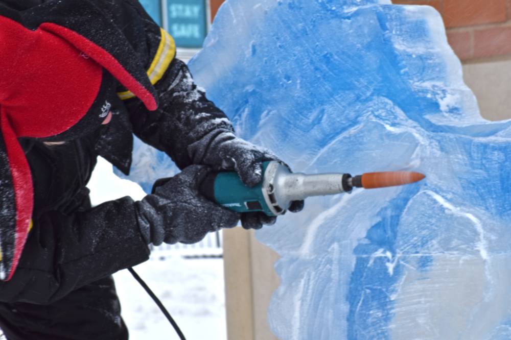 person sanding ice sculpture